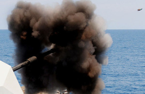 A 4.5-inch (11.5cm) gun is fired from a Royal Navy warship, with the shell captured in flight (stock image)