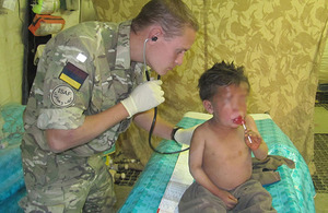 Captain Christopher Stewart treats an Afghan boy who suffered an adverse reaction after being stung by a hornet