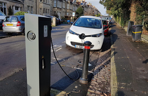 An electric car charging on a suburban street.