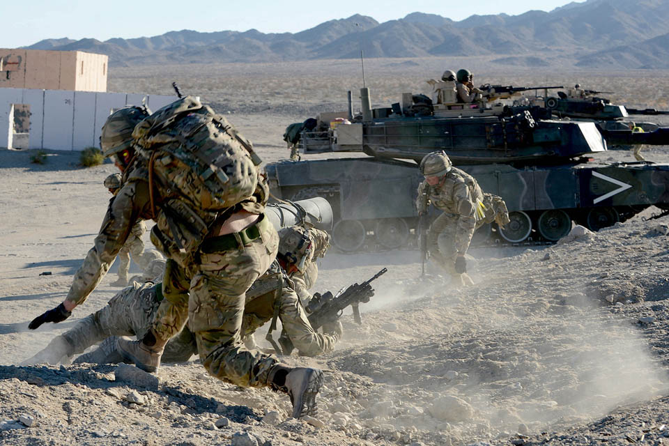 Royal Marines commandos attack enemy positions with support from an American M1 Abrams tank