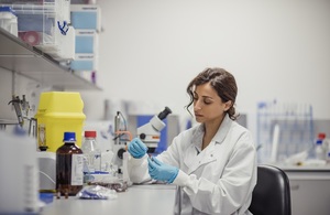 person in white coat working in laboratory