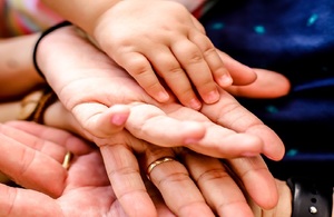 Adult and child hands placed on top of one another