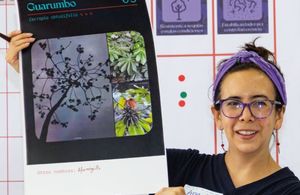 A scientist is holding an image showing a tree and its seeds.