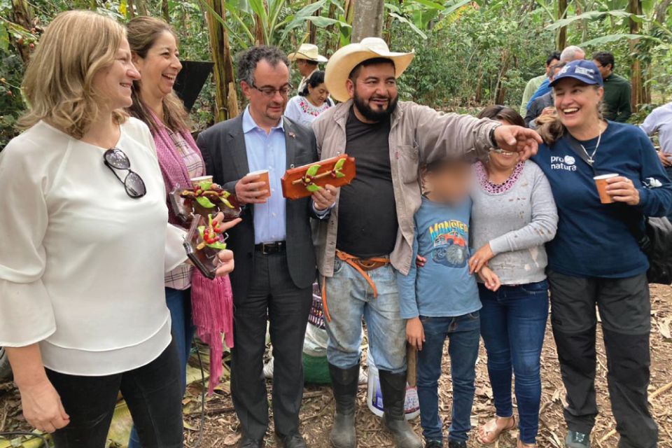 A group of people, including His Majesty's Ambassador to Mexico pose for the photo in a coffee plantation.
