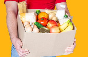 Stock image of a person holding a box of food supplies