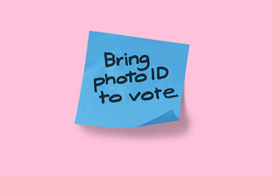 Post-it note reads "Bring photo ID to vote"