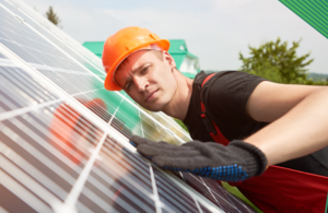 Man in a hard hat fixing solar panels