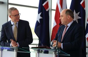 Australia Prime Minister Anthony Albanese and UK Defence Secretary Ben Wallace stand behind lecterns and in front of Australian and UK flags.