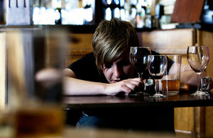 A drunken white female slumped over a pub table.