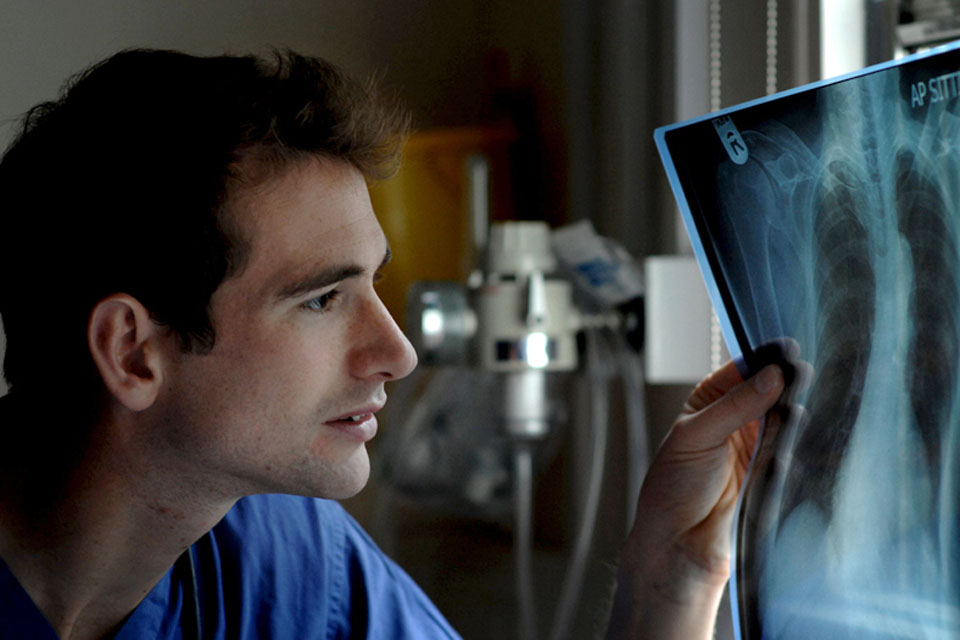 Army doctor Captain Nick Dennison examines an x-ray image