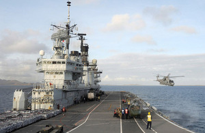 Army Air Corps Lynx helicopters from 659 Squadron on HMS Illustrious's flight deck as a Royal Navy Merlin hovers off the ship's port side [Picture: Leading Airman (Photographer) Nicky Wilson, Crown copyright]