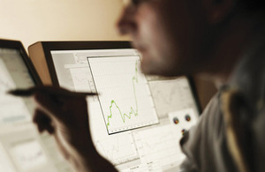 Man looking at data on two monitor screens