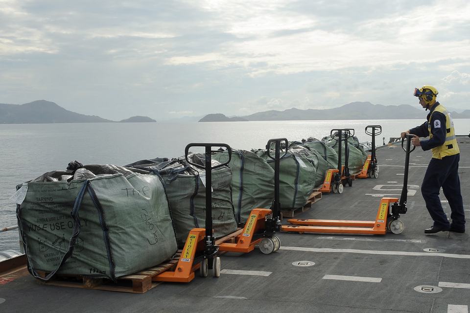 Bags of stores and aid on the flight deck of HMS Illustrious 