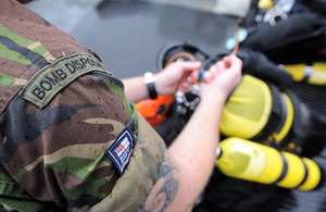 A Royal Navy diver from Southern Diving Unit 1 prepares to don his diving gear