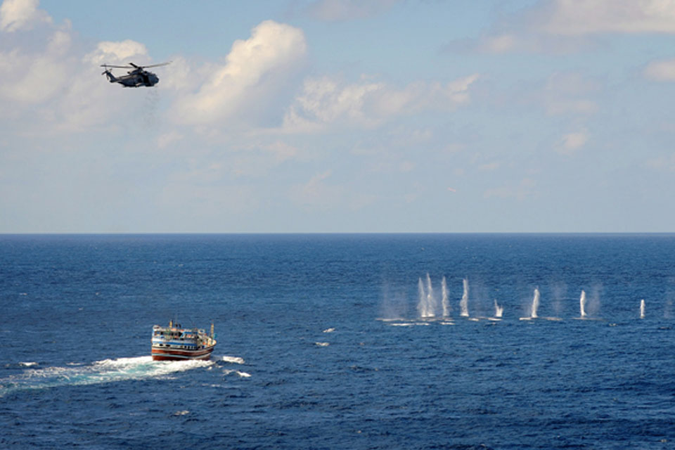 The gunner on HMS Somerset's Merlin helicopter fires shots across the bow of a pirated dhow 