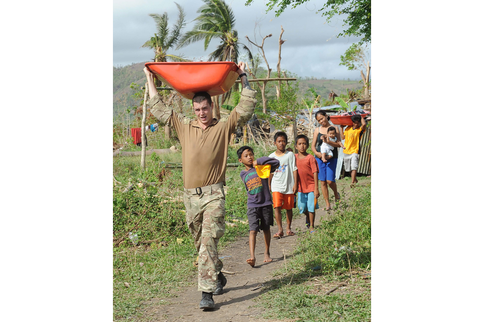 A Royal Marine carrying part of a wheelbarrow