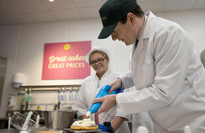 Chancellor icing a cake on visit to Morrisons in Watford.