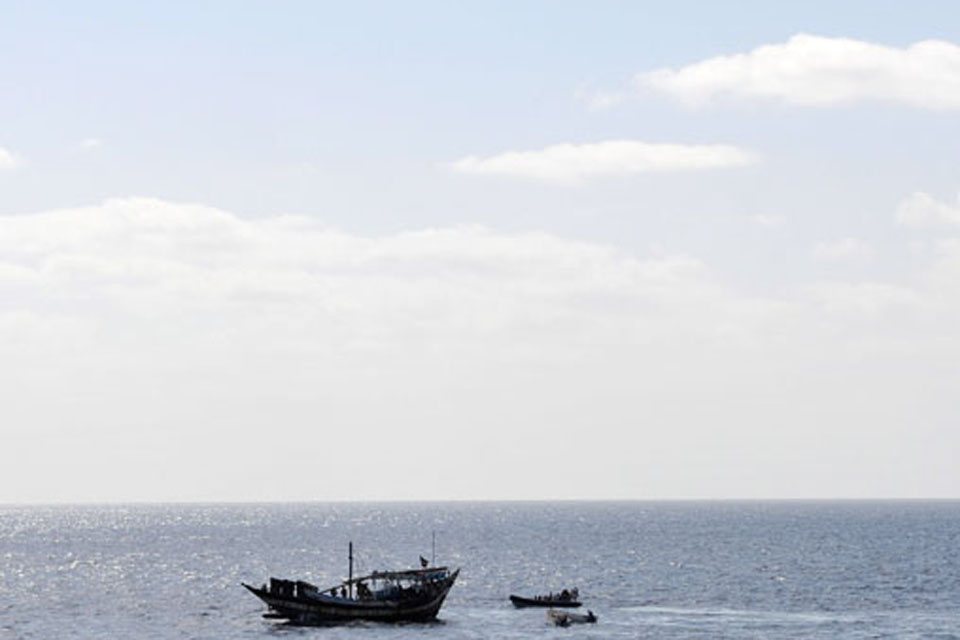 HMS Cornwall's Lynx helicopter hovers above the hijacked Yemeni dhow and pirate skiffs 