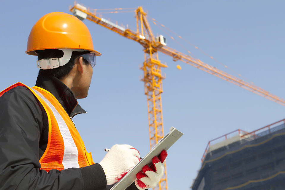 A crane is checked out by an inspector.