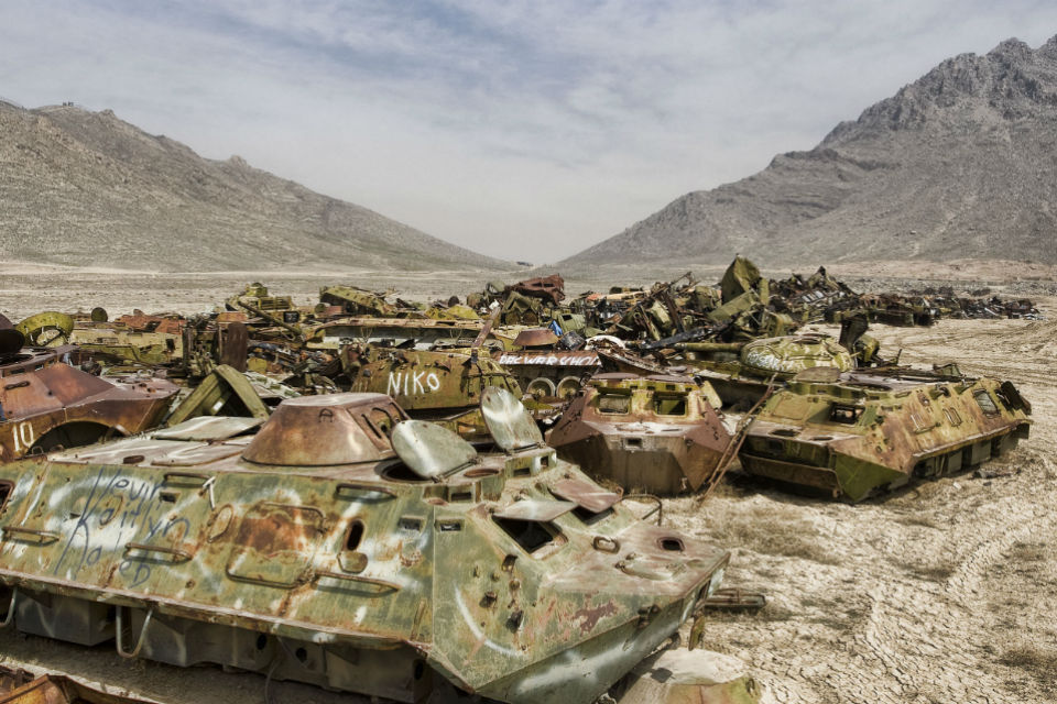 Old Russian tanks with graffiti on them.