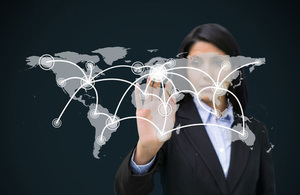 Businesswoman touching holographic world map