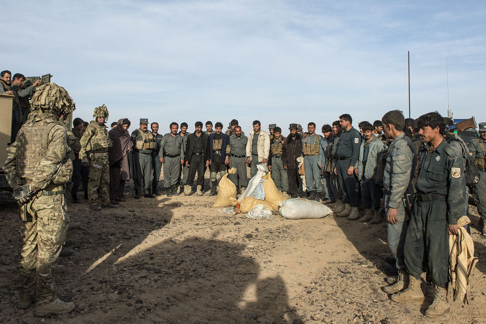 Afghan policemen and British soldiers with items seized from insurgents