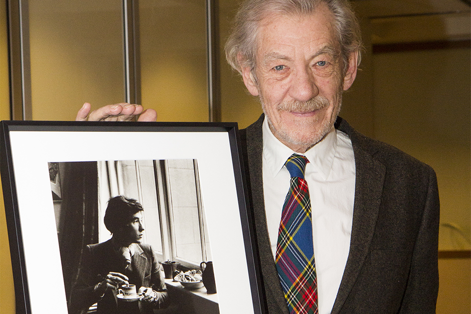 Sir Ian poses with the portrait taken by Michael Peto.