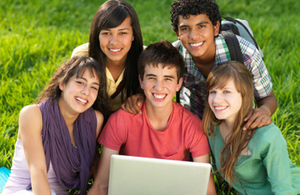 Children gather around a laptop