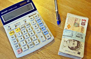 Calculator, a pen, and a bundle of £10 notes