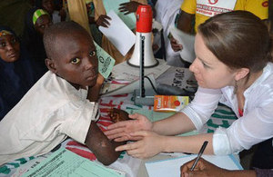 A lady examining a young african boy's arm