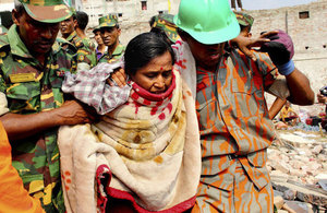 A woman is pulled from the rubble of the Rana Plaza complex in Savar by rescuers and civilian helpers.