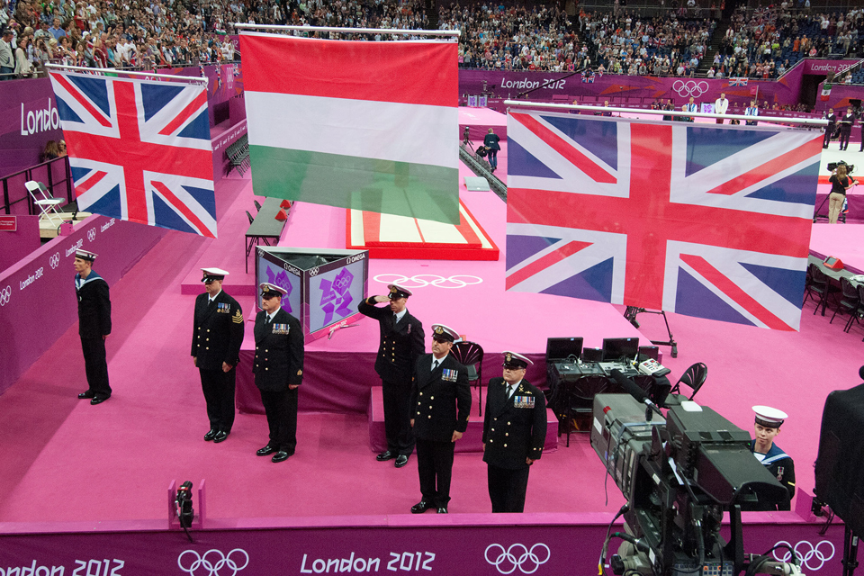 Royal Navy personnel raise flags