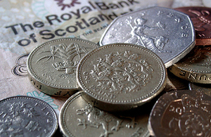 An image of coins laying on a bank note