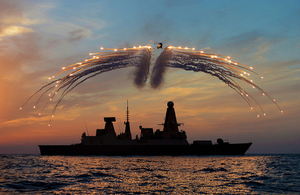 HMS Dragon's Lynx helicopter fires countermeasure flares over the ship at sunset [Picture: Leading Photographer Dave Jenkins, Crown copyright]