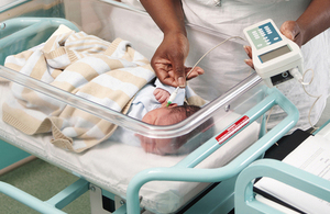 Newborn baby with nurse taking temperature