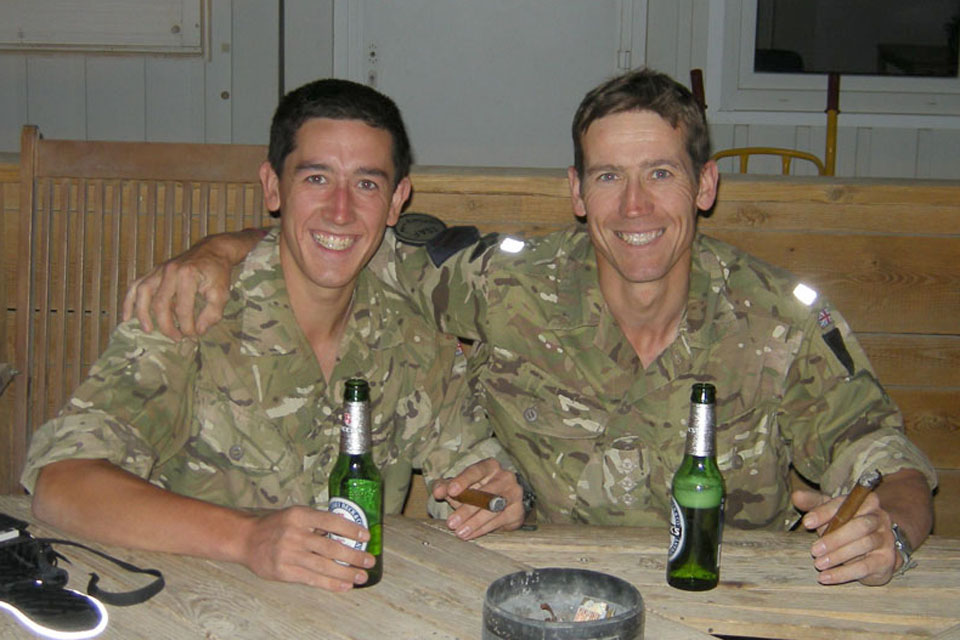 Marine James Hoyes and his father Captain Christopher Wilcock each enjoy a cigar and a non-alcoholic beer at Camp Bastion