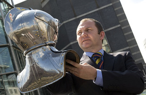 Afghanistan war veteran Lance Corporal David Sterling Brown holds aloft a steel helmet - part of the national collection held at the Royal Armouries Museum in Leeds