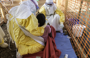 Doctors with Médecins Sans Frontières try to feed a young girl in the high contamination risk zone of a treatment centre in Sierra Leone. Picture: Sylvain Cherkaoui/Cosmos