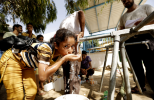 Photograph of a child drinking from a tap