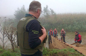 Environment Agency officers pull nets from the water