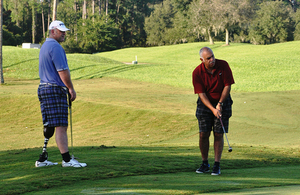 Zeno Gomes (right) playing golf as part of the Battle Back programme [Picture: Crown copyright]