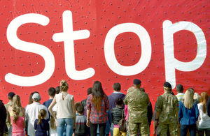 A group of people facing a big Stoptober sign in a red background