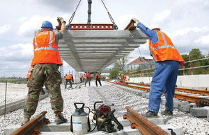 Workmen lowering rail into place