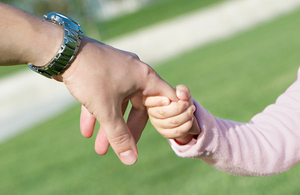 Adult holding child's hand