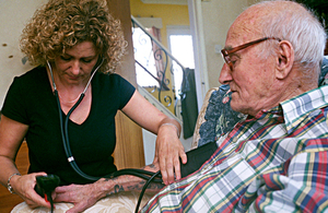 Carer taking pulse in the home