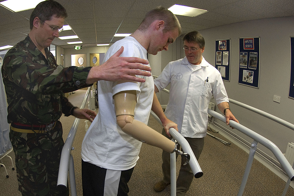 A soldier is guided in the use of his 3 prosthetic limbs at Headley Court