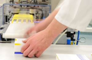 Hands in motion on the production line at a pharmaceutical manufacturer