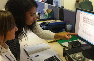 Caseworkers Anne Flowers, left, and Olivia Watkinson at computer discussing CRM14 eForm application