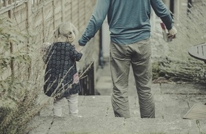 Father walking down some steps holding the hand of his young daughter.