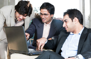 UK and Indian colleagues around a laptop